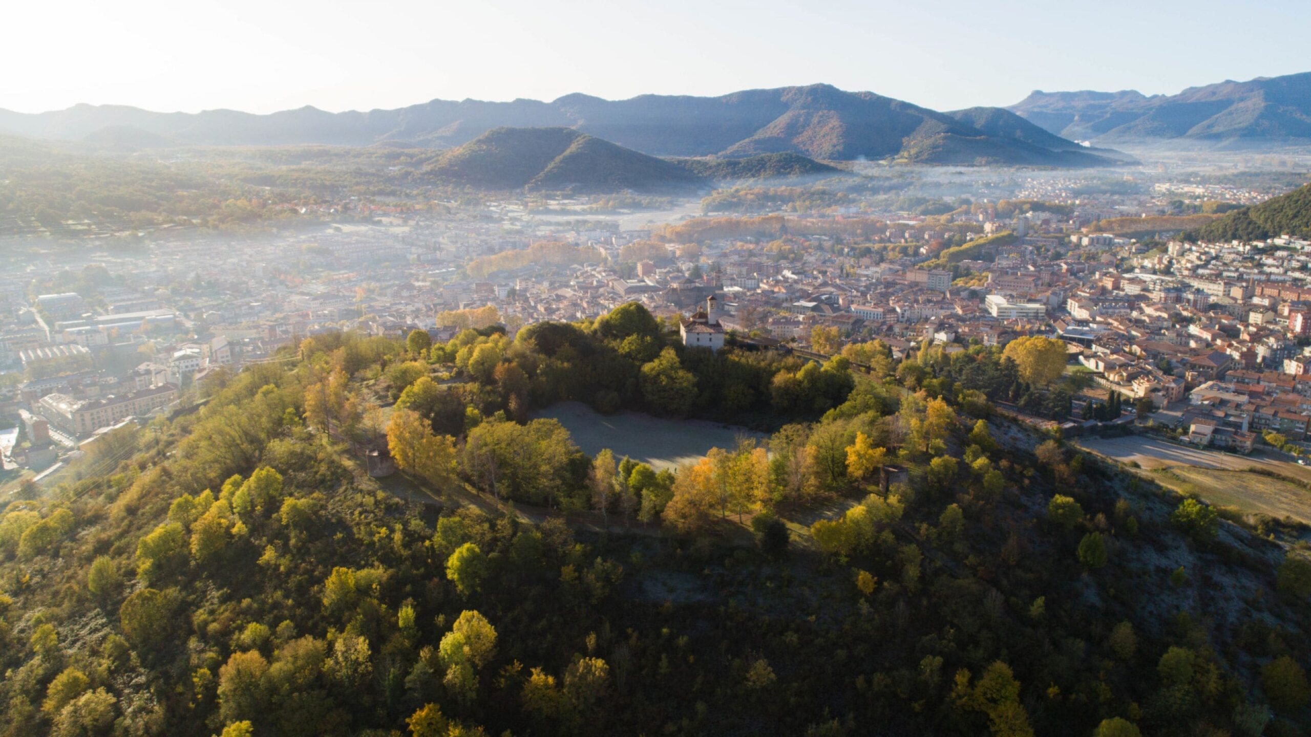 Vista aèria d'Olot amb el volcà Montsacopa i el paisatge de la Garrotxa